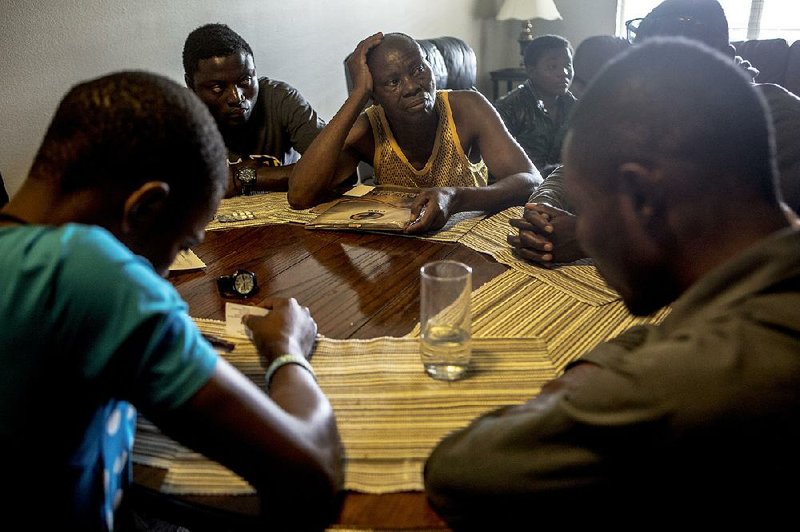 Watata Mwenda and his sons have a solemn moment after learning that their cousin, John, might be affected by the new “bona fide relative” stipulation to the U.S. travel ban. 