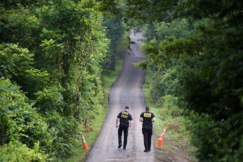 Pennsylvania State Police officers walk up a driveway Friday in Solebury, Pa., as the investigation of four missing young Pennsylvania men continues.