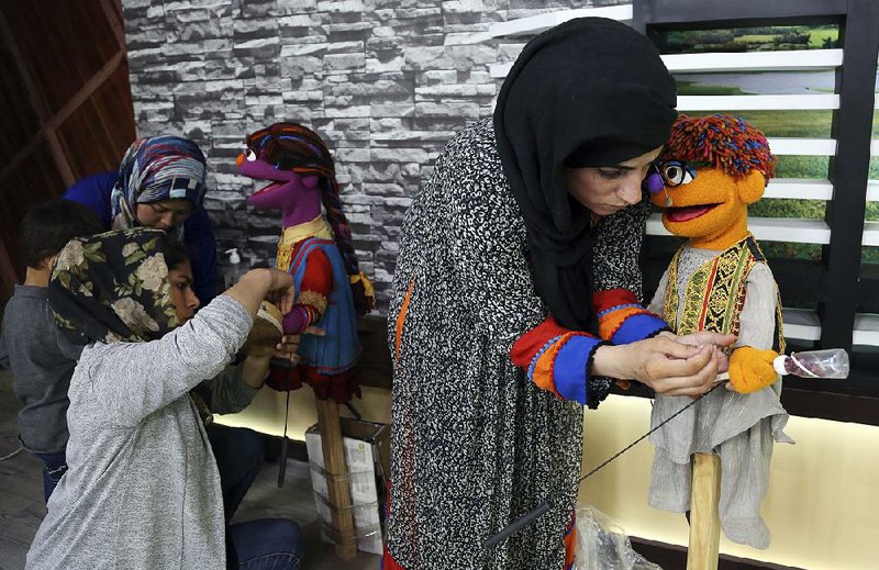 A puppeteer prepares the props for Zeerak (right), a new character for the Afghan version of Sesame Street, at a television station in Kabul, Afghanistan. 
