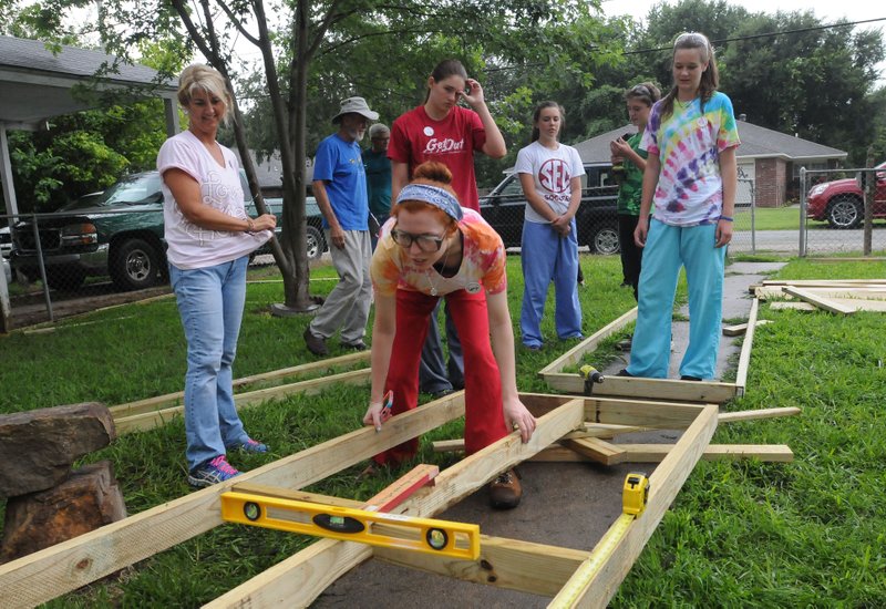 NWA Democrat-Gazette/FLIP PUTTHOFF 
Camryn Clarke (center) checks the level of a wheelchair ramp Tuedsay July 12, 2016 built by volunteers of the Ozark Mission Project. 