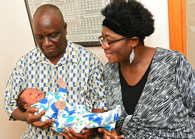 In a Thursday, July 13, 2017 photo, Isaiah Somuah Anim, 59, and his wife, Akosua Budu Amoako, 59, hold their son, Isaiah Somuah Anim Jr., in Dr. Khushru Irani's office in Niskayuna, N.Y. 