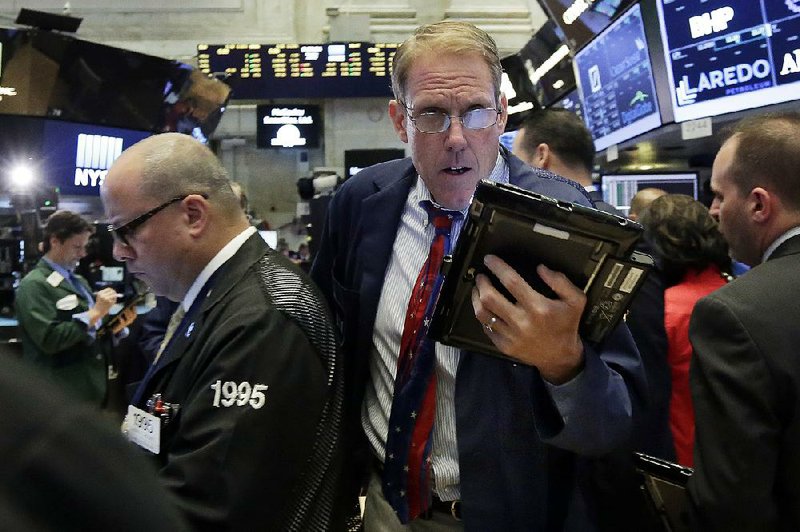 Trader Luke Scanlon (center) moves through a crowd on the floor of the New York Stock Exchangeon Monday. With stock indexes at or near record highs and another round of corporate earnings reports just beginning, investors didn’t make many big moves Monday and stocks wobbled between small gains and losses all day.