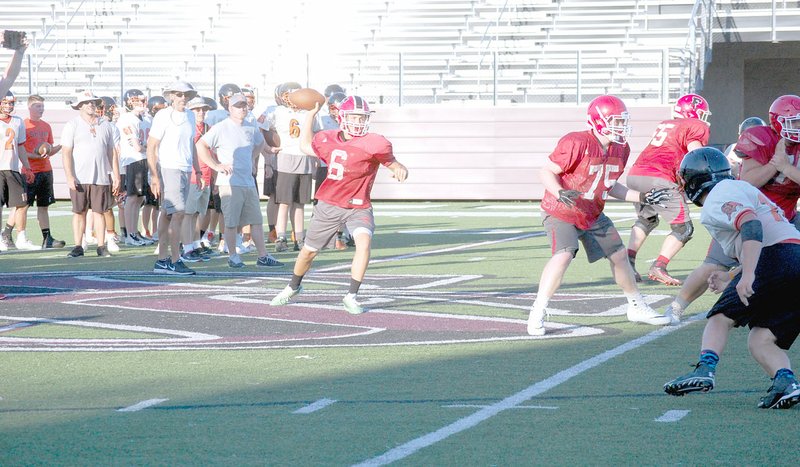 GRAHAM THOMAS NWA MEDIA Farmington quarterback Eric Hill drops back in the pocket to pass behind his offensive line while Gravette defenders attempt to stop the play. The scrimmage occurred Thursday during a camp hosted by Siloam Springs.