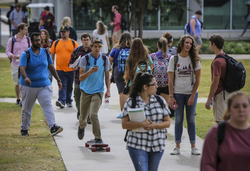 FILE - Joseph Reichman, a freshman from Dardanelle, rides his long board through heavy traffic on his way to class on the campus of Arkansas Tech University in Russellville in this 2017 file photo.