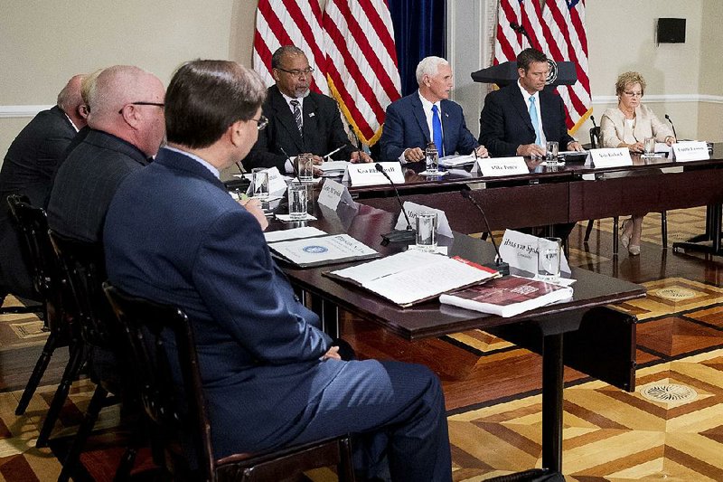 Vice President Mike Pence (center) gavels in the first meeting of the Presidential Advisory Commission on Election Integrity on Wednesday in Washington. Pence said the panel had no preordained results, while President Donald Trump suggested that states that have refused to comply with the commission’s request for voter information have something to hide.