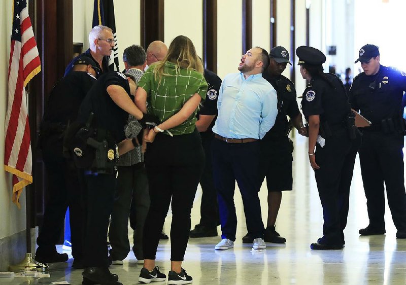 Capitol Police arrest New York City Council member Corey Johnson and other protesters Wednesday outside the offices of Senate Majority Leader Mitch McConnell. Demonstrations against repealing the Affordable Care Act were held at several senators’ offices, including those of Arkansas Republicans John Boozman and Tom Cotton. 