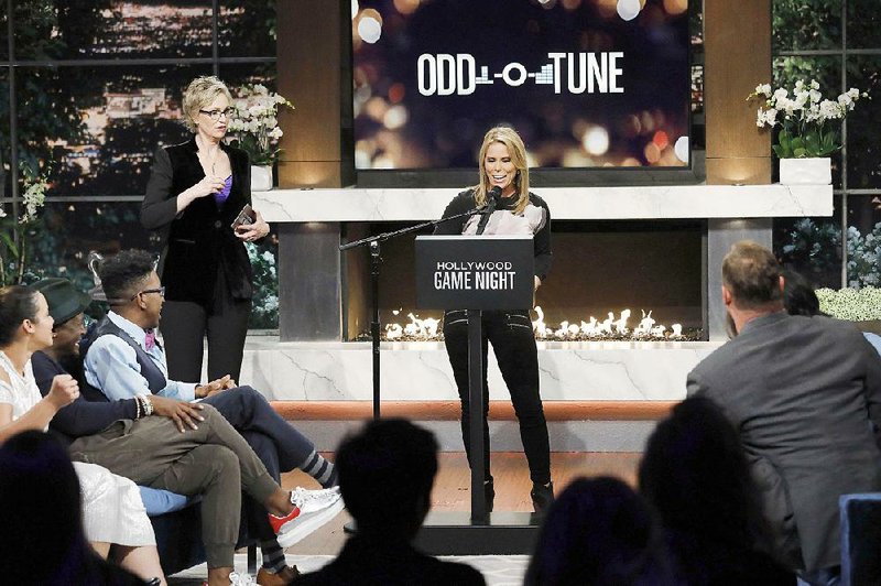 Jane Lynch (left) watches as Cheryl Hines gives clues on tonight’s episode of Hollywood Game Night on NBC.
