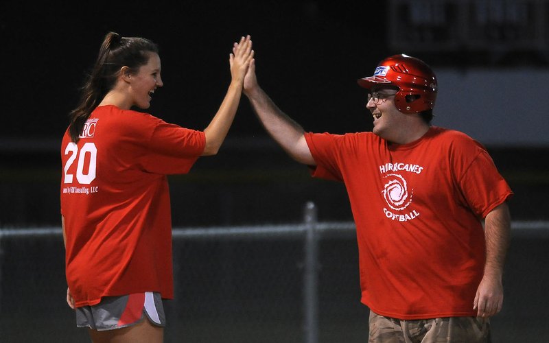 File photo Ally MacQuilkan (left), a volunteer with the Elizabeth Richardson Center softball team, high-fives Taylor Dark during a 2013 softball game at J.B. Hunt Park in Springdale. The “Beach Bingo Bash” on July 29 will benefit children and adults with disabilities the organization serves in Washington, Benton and Madison counties.