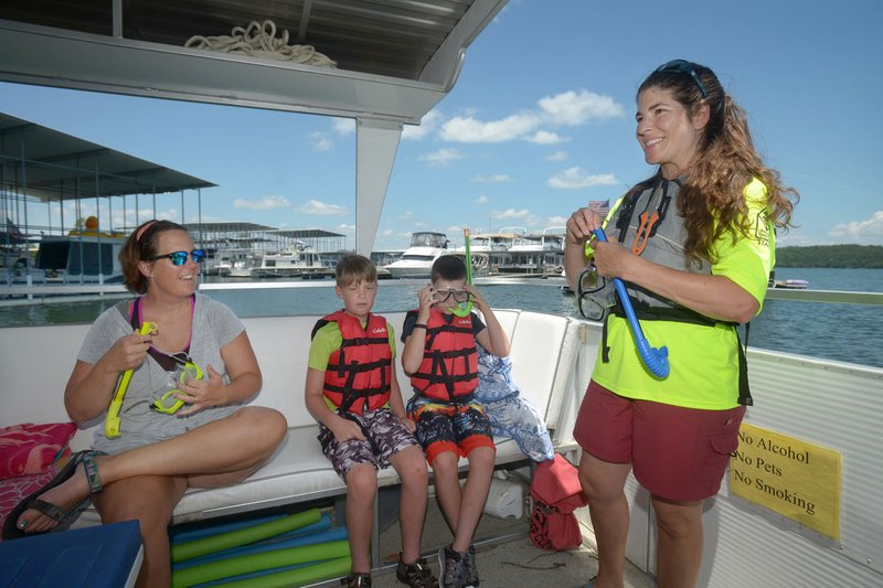 NWA Democrat-Gazette/BEN GOFF @NWABENGOFF Allison Byford of Springdale (from left) and her sons Walker Byford, 9, and Will Byford, 11, listen as Rebekah Penny, interpreter at Hobbs State Park - Conservation Area, explains how to use a snorkel July 10, as a snorkeling class offered by the park heads out onto Beaver Lake from Rocky Branch Marina.