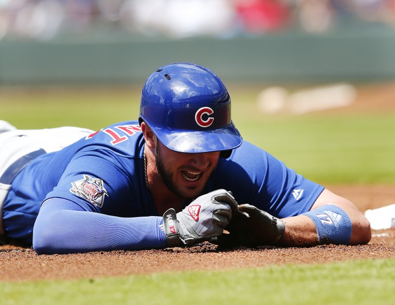 Chicago Cubs third baseman Kris Bryant (17) holds his finger after being injured diving into third base in the first inning of a baseball game against the Atlanta Braves Wednesday, July 19, 2017, in Atlanta. (AP Photo/John Bazemore)