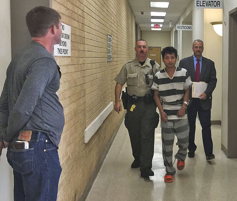 A sheriff's deputy escorts Mei Ka Sin on Thursday to a room in the Benton County Courthouse in Bentonville to speak with Jay Saxton, Benton County's chief public defender. Sin was arrested in connection with capital murder and is being held without bond in the Benton County Jail.