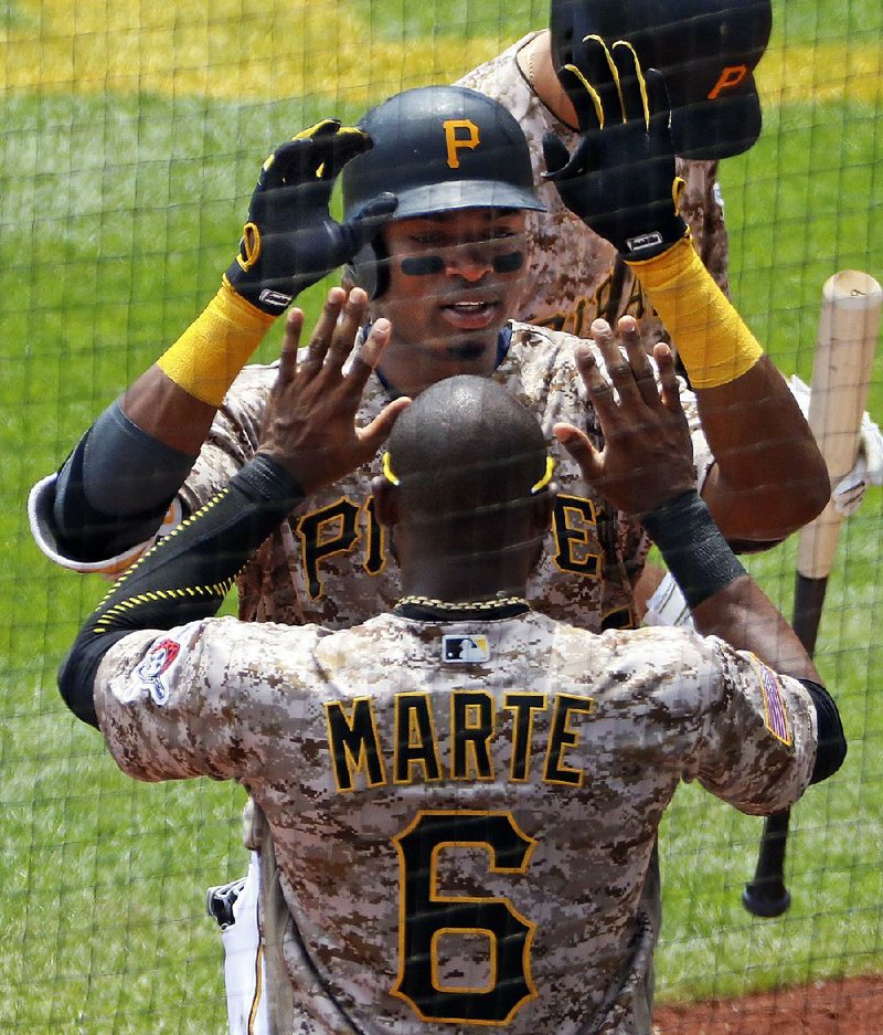 Pittsburgh’s Gregory Polanco (front) celebrates with teammate Starling Marte after hitting a home run Thursday
during the Pirates’ 4-2 victory over the Milwaukee Brewers in Pittsburgh.