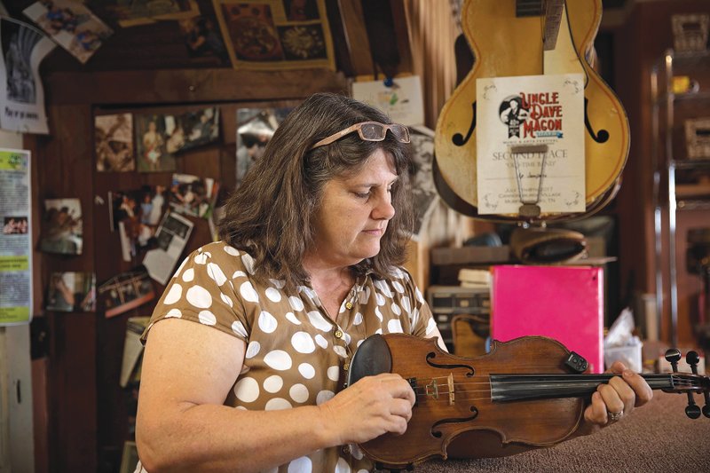 Shay Pool of Mountain View tunes a violin. She said music is everywhere. “We hear it in stores, on streets, from cars, TVs and churches. It makes our world a better place,” she said.