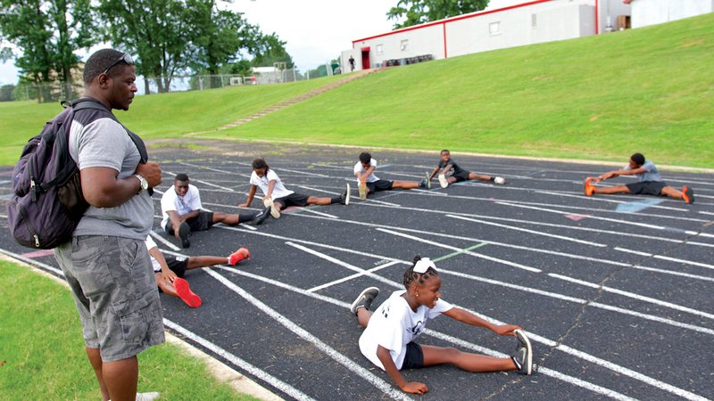 Coach Larry Cunningham oversees members of the Cunningham Racing Track Club in Jacksonville. They are preparing for the Amateur Athletic Union Junior Olympics in Detroit, which will begin later this month.