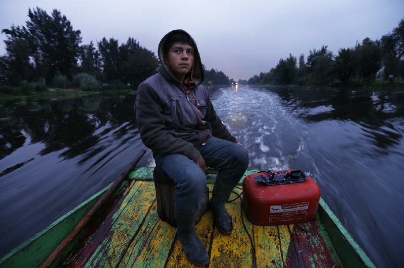 Gerardo Cristobal navigates his boat as he ferries farmers and laborers to their floating farms called “chinampas” in Xochimilco, Mexico City. 