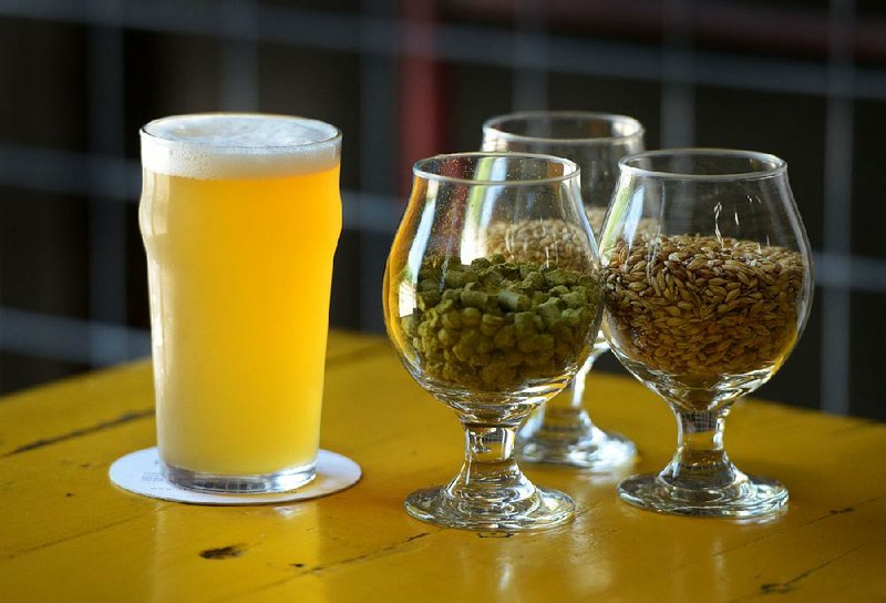 A pint of a pale ale brewed from ingredients including caramel malt, white wheat and citra hop pellets sits on a table Friday at Ozark Beer Co. in Rogers. The brewery has partnered with CrystalBridges Museum of American Art to produce the beer, inspired by notes found in a journal by Buckminster Fuller.