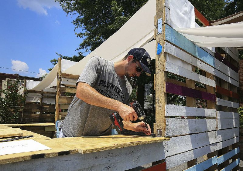 FILE — Caleb Tyson, co-chairman of the PopUp Argenta, works setting up for the group's event on Main Street in North Little Rock in this July 21, 2017, photo.  A PopUp event in southwest Little Rock is planned next month.