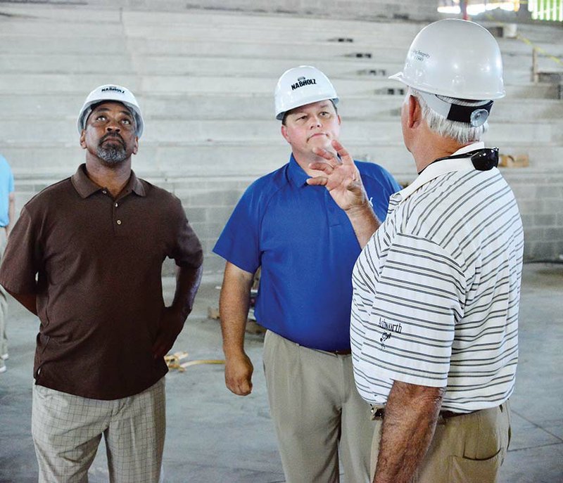 From left, Former Morrilton High School basketball player Donnie Parks and Shawn Halbrook, superintendent 
of the South Conway School District in Morrilton, listen to a story told by former Morrilton Devil Dogs 
assistant coach Johnny Hoyt during a tour of the new Devil Dog Arena in Morrilton. The John Widner 
Memorial Devil Dog Open golf tournament was held in June to help raise funds to name the court in memory 
of Widner.