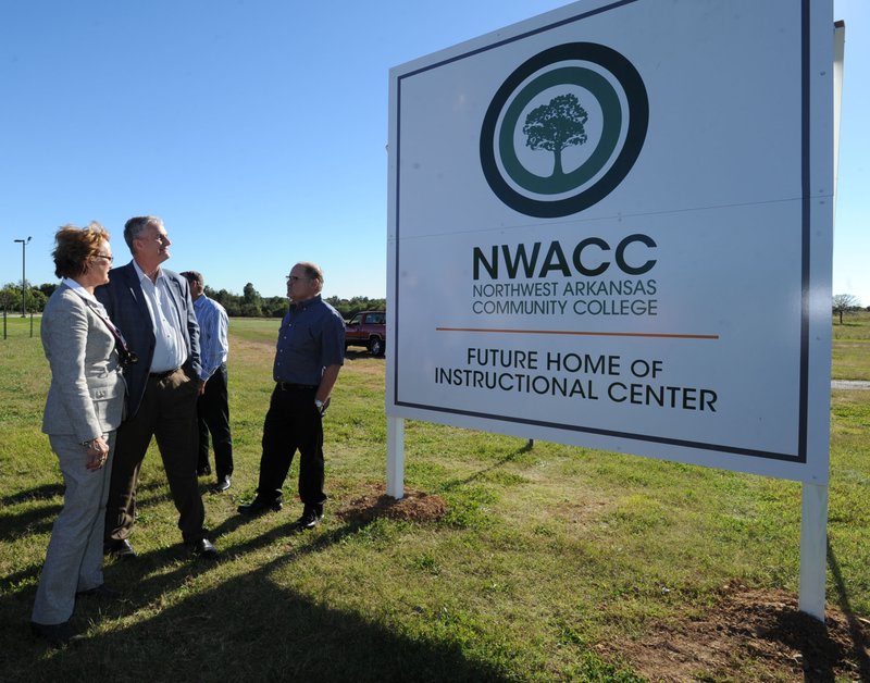 Evelyn Jorgenson, president of NorthWest Arkansas Community College, left, speaks with Springdale Mayor Doug Sprouse Wednesday, Oct. 15, 2014, during a ceremony to unveil a sign at the site of a planned Washington County instruction site for the college west of Arvest Ballpark in Springdale.