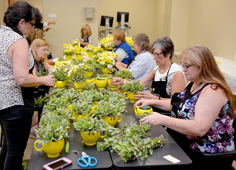 Janelle Jessen/Siloam Sunday Members of the Siloam Springs Regional Hospital&#8217;s Healthy Community Advisory Council helped florist Melanie Pentecost, owner of Siloam Flowers &amp; Gifts, create 60 bouquets for Make Someone Smile Week. The flowers were distributed to hospital patients.