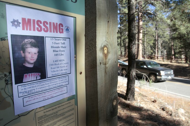 In this Nov. 26, 2012 file photo, a missing poster of 13-year-old Dylan Redwine hangs on a trail head sign next to Vallecito Reservoir in Vallecito, Colo. Police have arrested Mark Redwine for the death of his 13-year-old son, Saturday, July 22, 2017. Mark Redwine's arrest Saturday in Bellingham, Washington, follows a grand jury indictment for second-degree murder and child abuse resulting in death. (Shaun Stanley/The Durango Herald via AP, File)