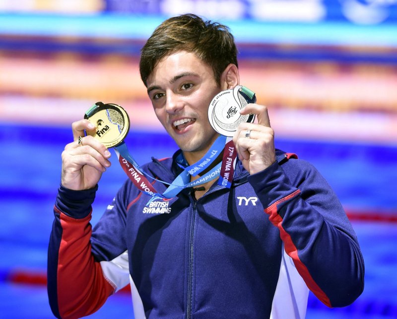 Thomas Daley of Great Britain shows off his gold medal won in the men’s diving 10-meter platform final and with his silver medal won in the mixed 3-meter synchro springboard final on Saturday during the 17th FINA Swimming World Championships in Duna Arena in Budapest, Hungary. 