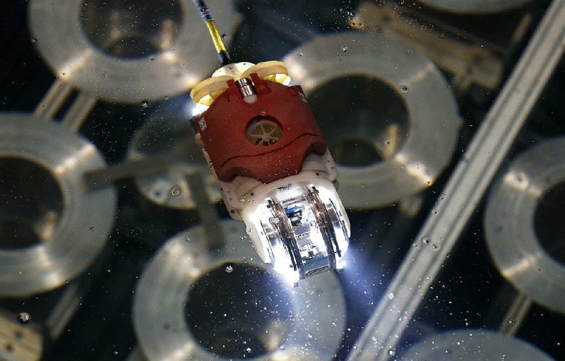 A newly developed robot for underwater investigation at Japan’s Fukushima nuclear plant’s damaged reactor moves in the water at a Toshiba Corp. test facility in Yokosuka in early summer.