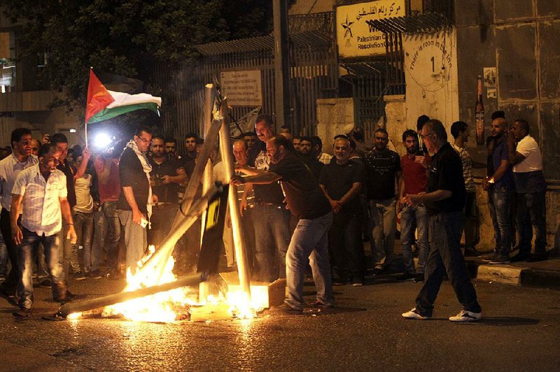 Palestinians burn mock metal detectors Sunday in Bethlehem during a demonstration against the devices’ use at a Jerusalem mosque.