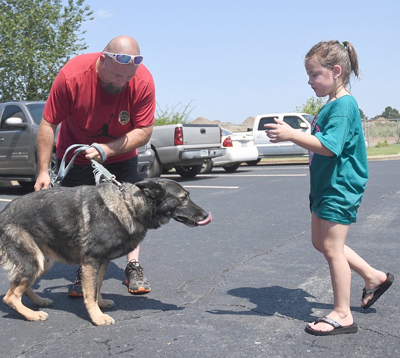 The Sentinel-Record/Mara Kuhn GOOD DOG: Josh Mayhood, left, and Marlee, Mayhood, 6, of Hot Springs, right, pet a dog that was up for adoption during Summerthon at Hot Springs Animal Services' shelter on Saturday.