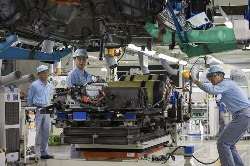 Assembly line workers install hydrogen tanks in a Mirai fuel cell vehicle at the Toyota Motomachi plant in Toyota City, Japan, in this 2016 file photo.