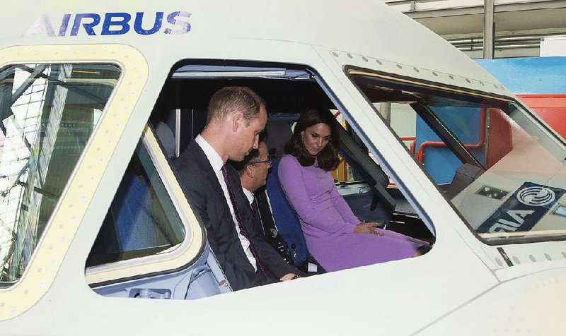 Britain’s Prince William (left), his wife Kate, the Duchess of Cambridge, and Assembly Line Vice President Olaf Lawrenz tour the cockpit of an A320 jet Friday at an Airbus factory in Hamburg, Germany. Airbus is working on a new sales campaign to increase orders of its much larger A380 superjumbo jet.