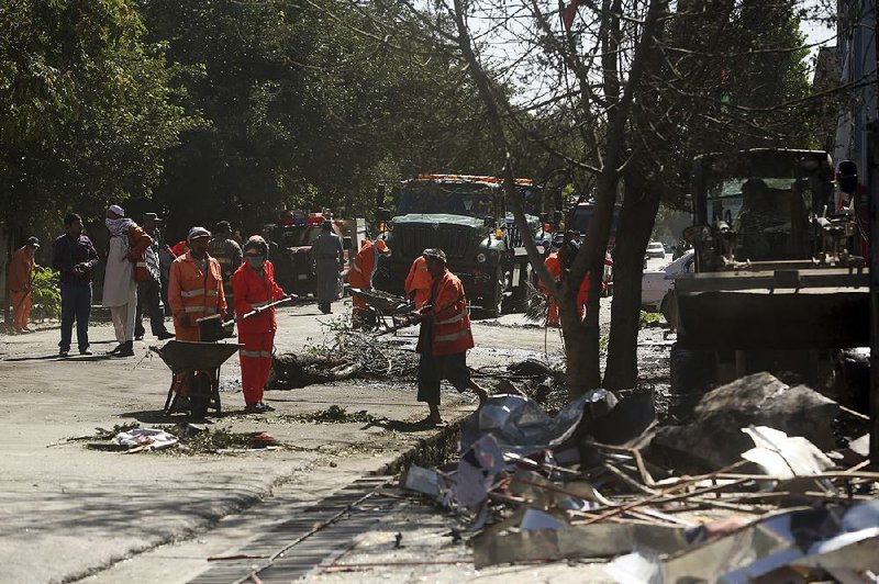 Municipality workers Monday clean up the scene of a suicide attack in Kabul, Afghanistan.