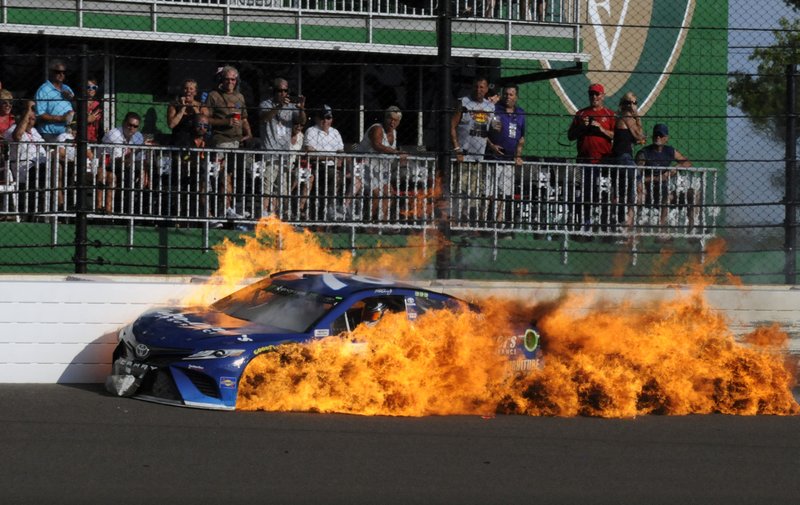 The Associated Press UP IN FLAMES: The car driven by Martin Truex Jr. burns after a crash with Kyle Busch during the NASCAR Brickyard 400 auto race at Indianapolis Motor Speedway in Indianapolis, Sunday. Neither driver was injured in the crash.