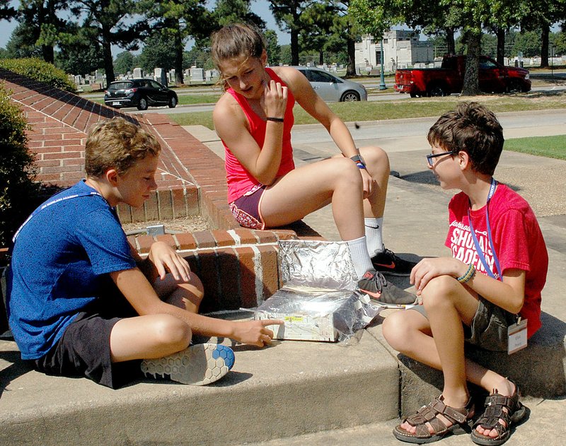 Janelle Jessen/Herald-Leader Wilson Cunningham, Faith Ellis and Elliot Posey checked their solar oven to see how well it baked chocolate chip cookie dough during Scholar&#8217;s Science Academy at John Brown University on Thursday. Elementary and middle school students spent the week learning about STEM (science, technology, engineering and math) subjects.
