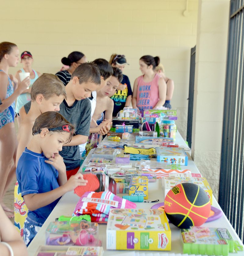 Michael Burchfiel/Herald-Leader Participants in the library&#8217;s summer reading program pored over the prizes available to the program&#8217;s highest achievers. The end of year party was held at the Family Aquatic Center this year to address high summer temperatures, said the library&#8217;s children&#8217;s coordinator, Delilah Williamson. The event could potentially be held again at the pool next year.