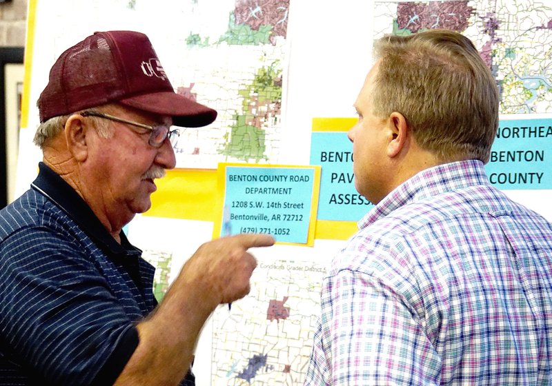County Judge Barry Moehring (right) discusses county roads with Gary LaRue of Siloam Springs at Monday's town hall meeting in Gentry.
