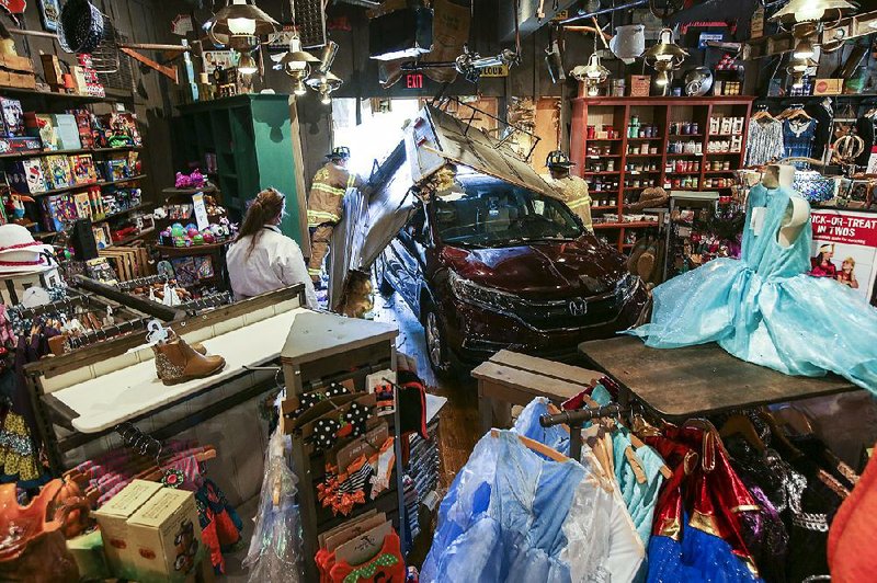 Arkansas Democrat-Gazette/MITCHELL PE MASILUN --7/26/2017--
Firefighters clear debris after a vehicle drove through the wall of the Cracker Barrel in West Little Rock Wednesday, July 26, 2017.