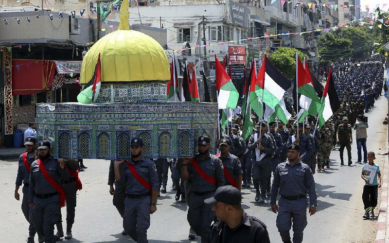 Hamas security officers carry a model of the Al-Aqsa mosque during a march Wednesday in Gaza against Israeli security measures at the contested Jerusalem shrine. 