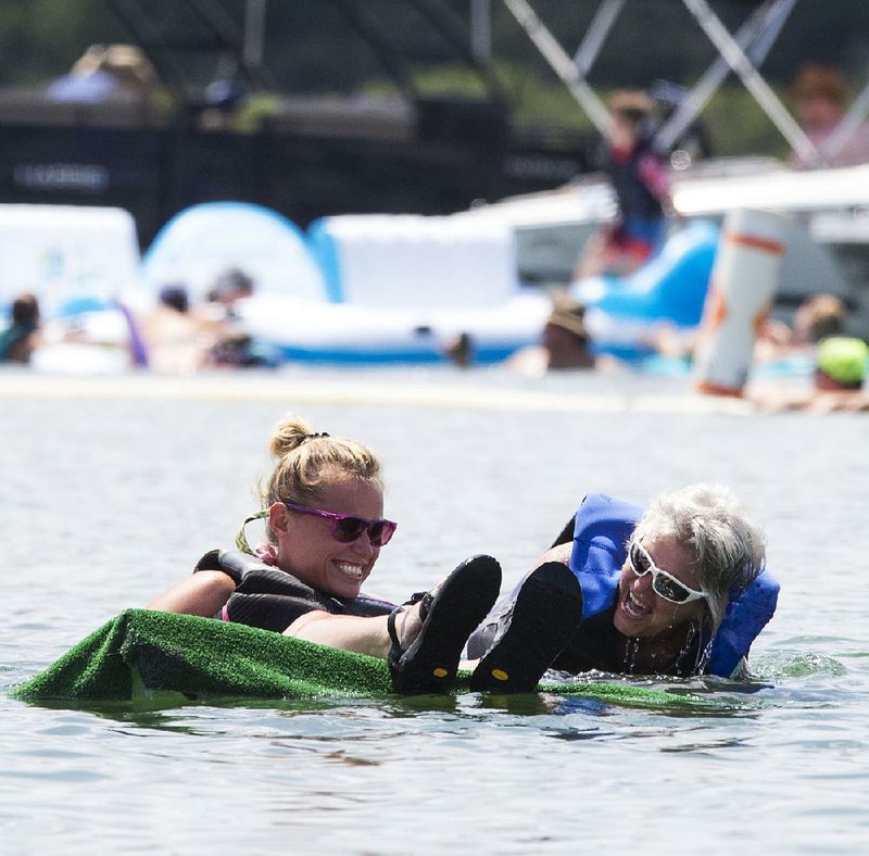 Dezirae Plummer (left) and Tresia Orellana experience that sinking feeling at last year’s World Championship Cardboard Boat Races in Heber Springs.
