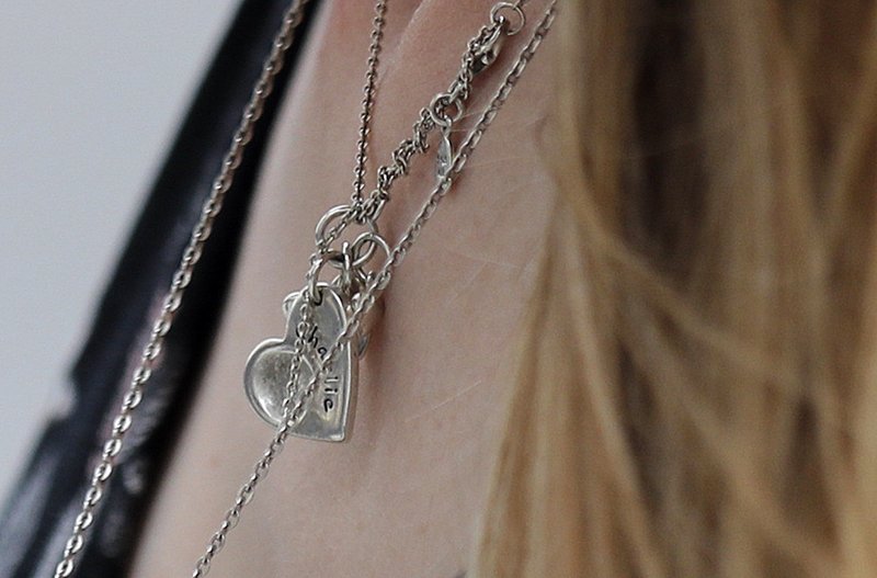 Connie Yates, mother of critically ill baby Charlie Gard, wears pendant in honour of her son as she arrives at the Royal Court of Justice in London, Wednesday, July 26, 2017. A British judge is set to rule on where Charlie Gard, a baby with a rare genetic disease, will spend the last days of his life. (AP Photo/Frank Augstein)