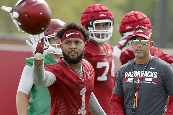 Arkansas receiver Jared Cornelius catches his helmet during practice Thursday, July 27, 2017, in Fayetteville. 