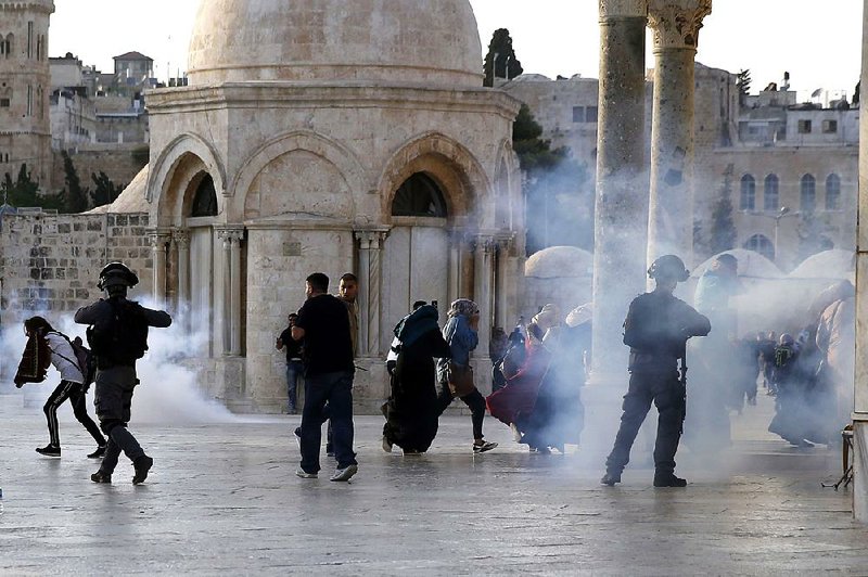 Israeli border police throw tear gas towards Palestinians on Thursday next to the Dome of the Rock mosque in the Al-Aqsa mosque compound.