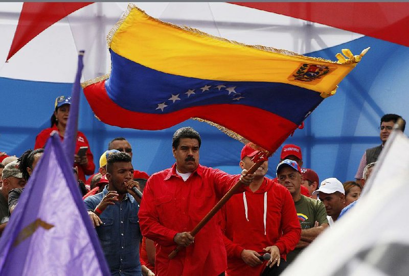 Venezuela’s President Nicolas Maduro waves the Venezuelan flag during a rally Thursday in Caracas. 
