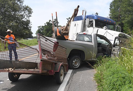 The Sentinel-Record/Mara Kuhn HEAD-ON: A log truck and a 2008 Chevrolet pickup truck sit in the westbound lane of the 6000 block of Highway 70 west following a nearly head-on collision around noon Thursday.