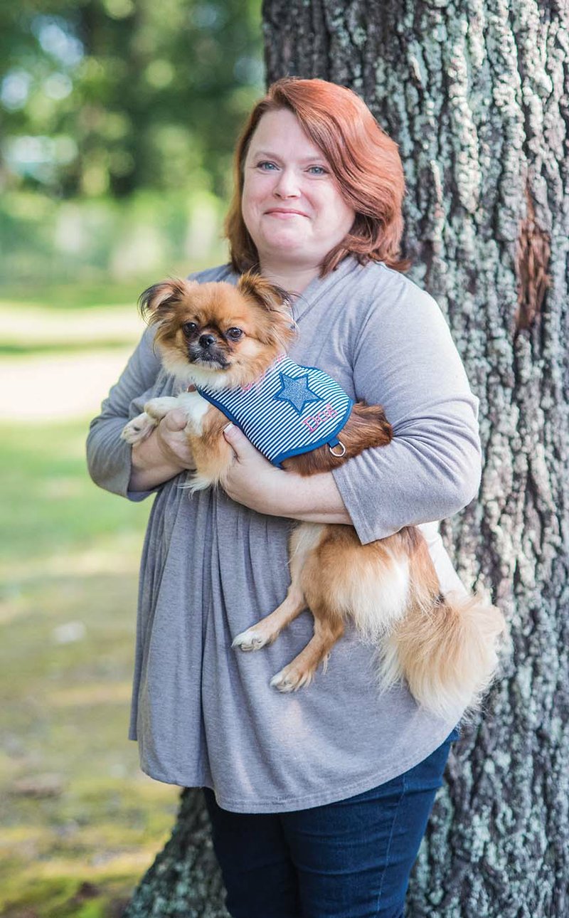 Robin Walloch of Conway holds her service dog, Whimsy, a Tibetan spaniel. Walloch, who is a trainer and an animal behaviorist, has a rare form of arthritis and a heart condition. She helped get legislation enacted this year in the Arkansas Legislature that aligns state law regarding service animals with the Americans With Disabilities Act, which covers service animals for psychological conditions, as well as autism, diabetes and more.