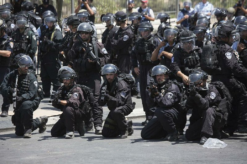 Israeli police officers aim their weapons Friday as Palestinians protest in Jerusalem. The police were on high alert ahead of Muslim prayers at the major Jerusalem shrine at the center of recent tensions, but the day ended peacefully at the site.  