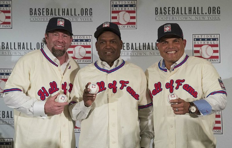 In this Jan. 19, 2017, file photo, Hall of Fame inductees Jeff Bagwell, left, Tim Raines, center, and Ivan Rodriguez, poses for a photo during a news conference, in New York. Bagwell, Raines, Rodriguez, Bud Selig and John Schuerholz each carved his own niche in major league baseball, and on Sunday they will receive the game's ultimate reward _ induction into the Hall of Fame. 