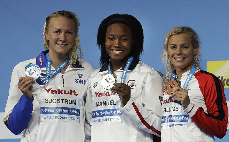 United States' gold medal winner Simone Manuel is flanked by Sweden's silver medal winner Sarah Sjostrom, left, and Denmark's bronze medal winner Pernille Blume, right, after the women's 100-meter freestyle final during the swimming competitions of the World Aquatics Championships in Budapest, Hungary, Friday, July 28, 2017. 