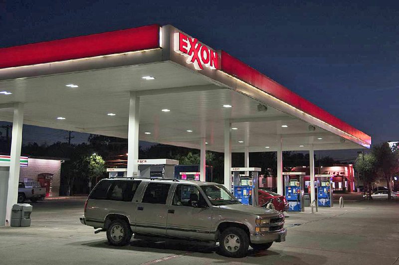 A vehicle leaves an Exxon Mobil gas station in Dallas. Exxon said Friday that higher prices for oil and gas helped it offset a 1 percent decline in production.