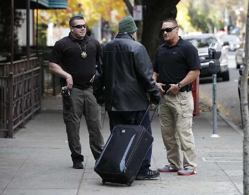 Parole agents Andrew Correa (left) and Clint Cooley talk with a sex-offender parolee in Sacramento, Calif., on Dec. 1, 2015, after locating him by using the global positioning device he wears. 